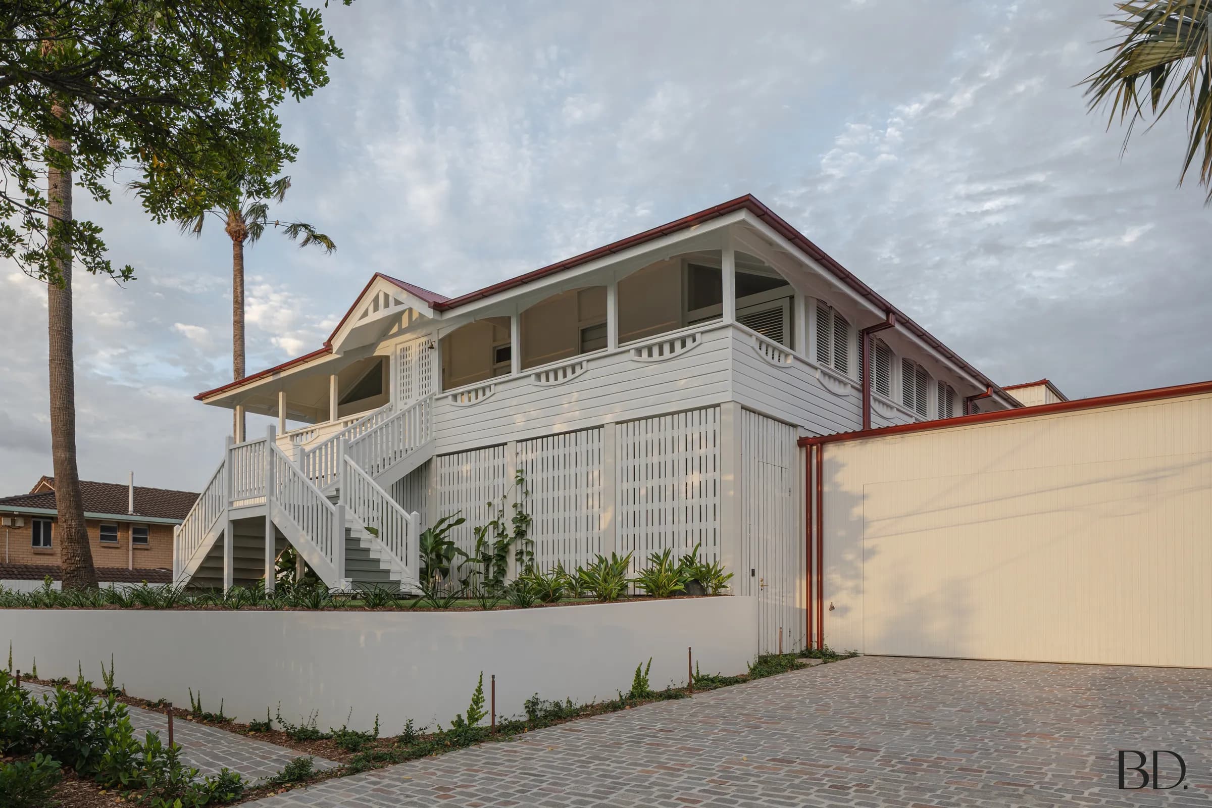 Harrison Street — restored white weatherboard Queenslander with red roof trim and verandah detailing, Brisbane.