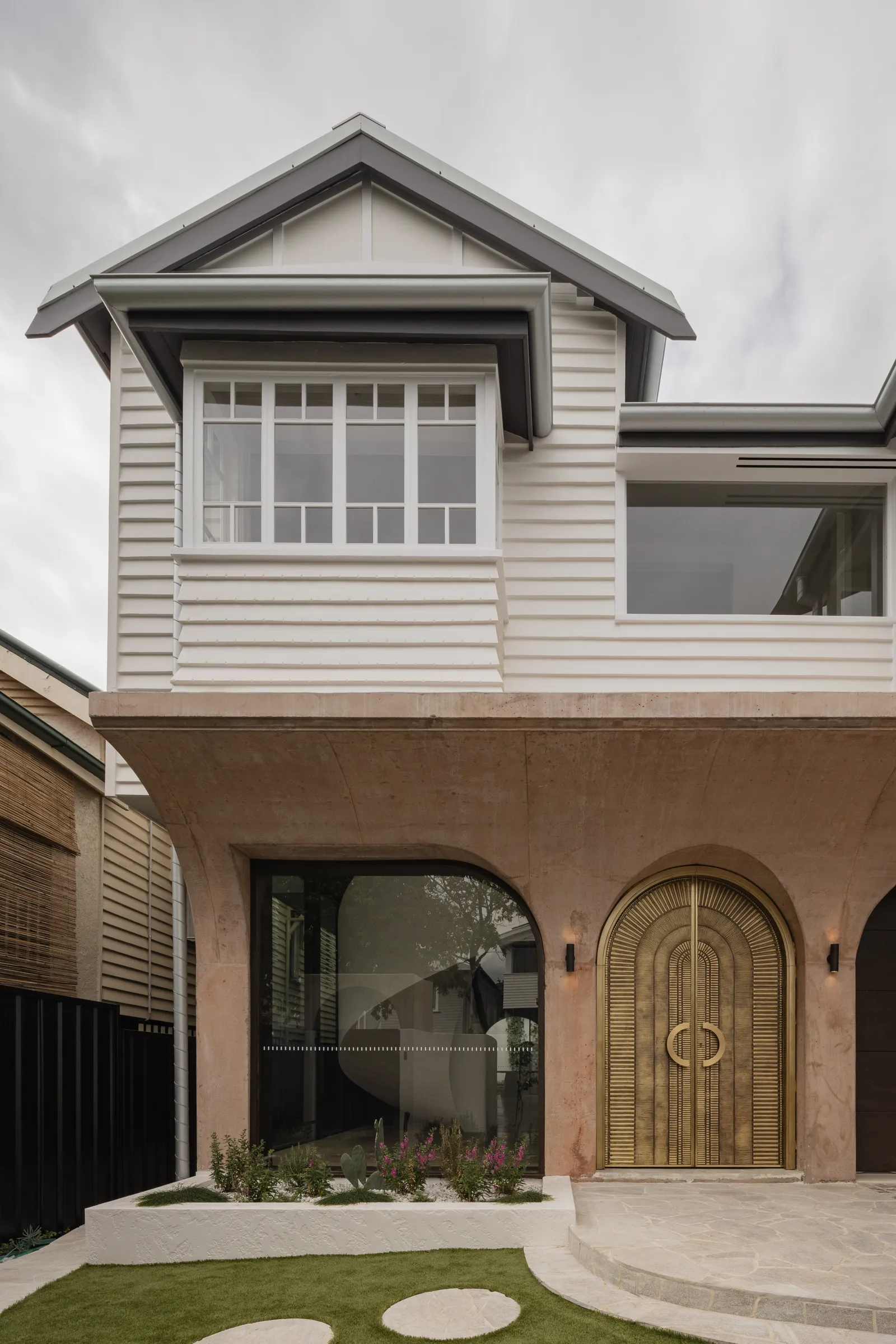 Mark Street — rendered Brisbane home with brass arched entry door and weatherboard upper level.